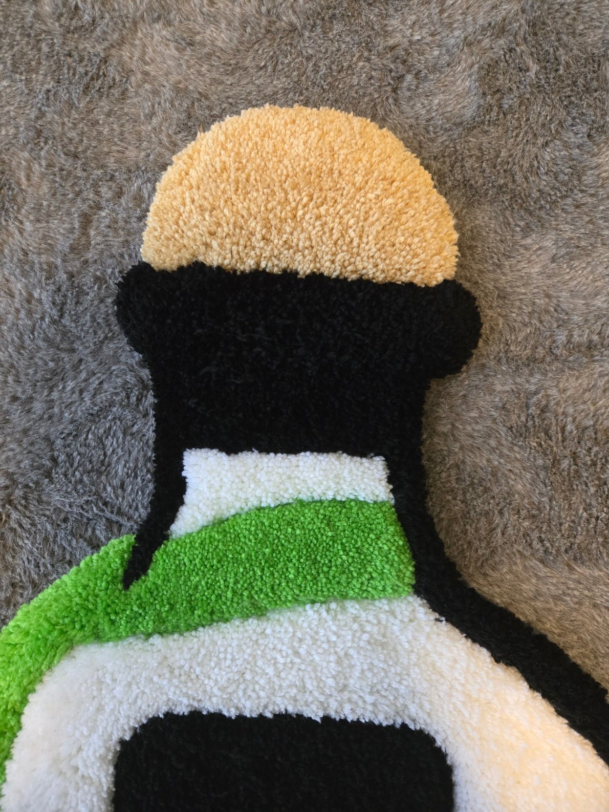 Patron bottle custom tufted premium rug laying on carpet - top view