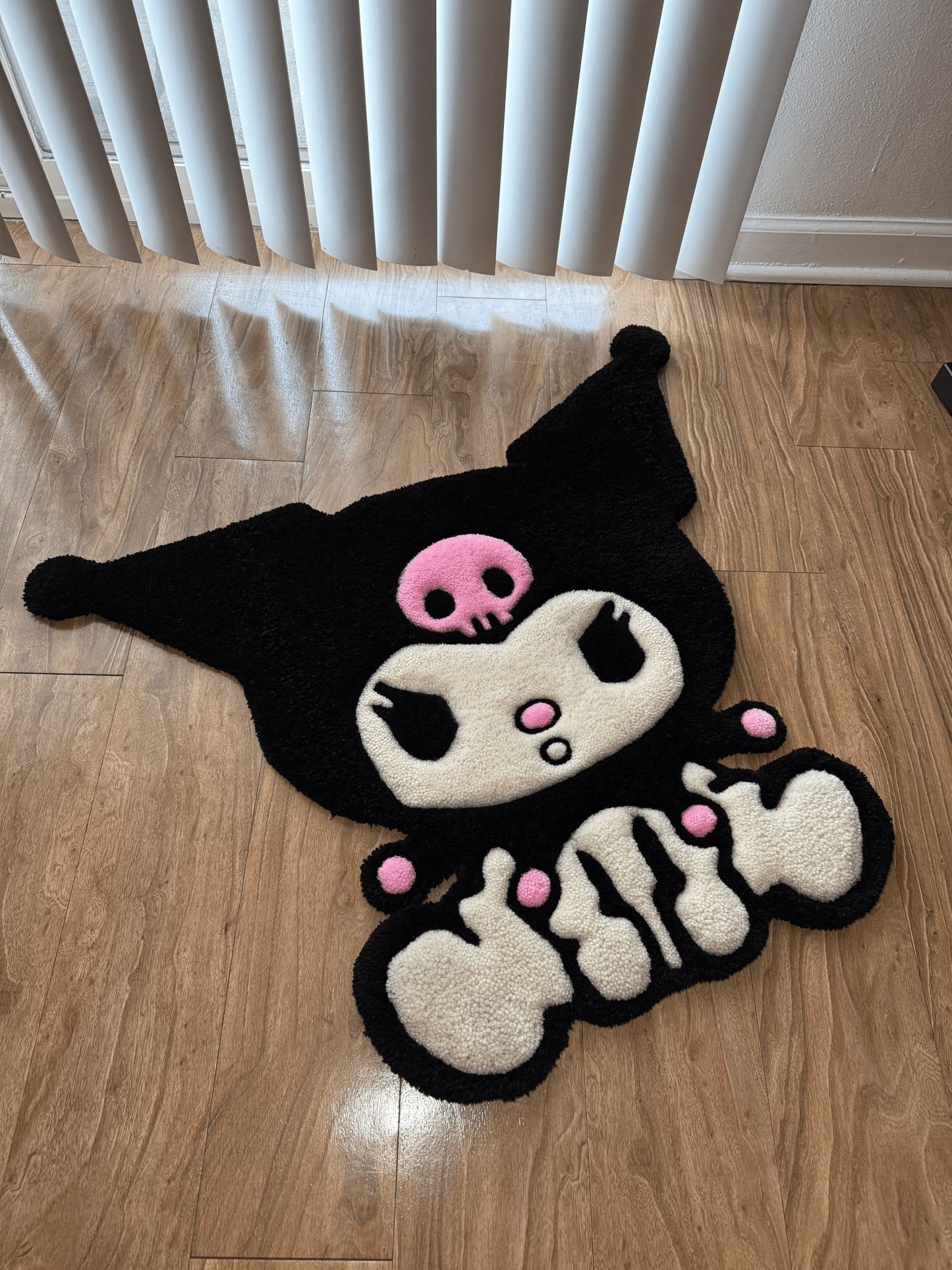 Large full body kuromi custom tufted premium rug laying on wood flooring - side view